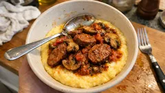 Polenta con salsiccia e funghi al sugo: la ricetta rustica che scalda la tavola